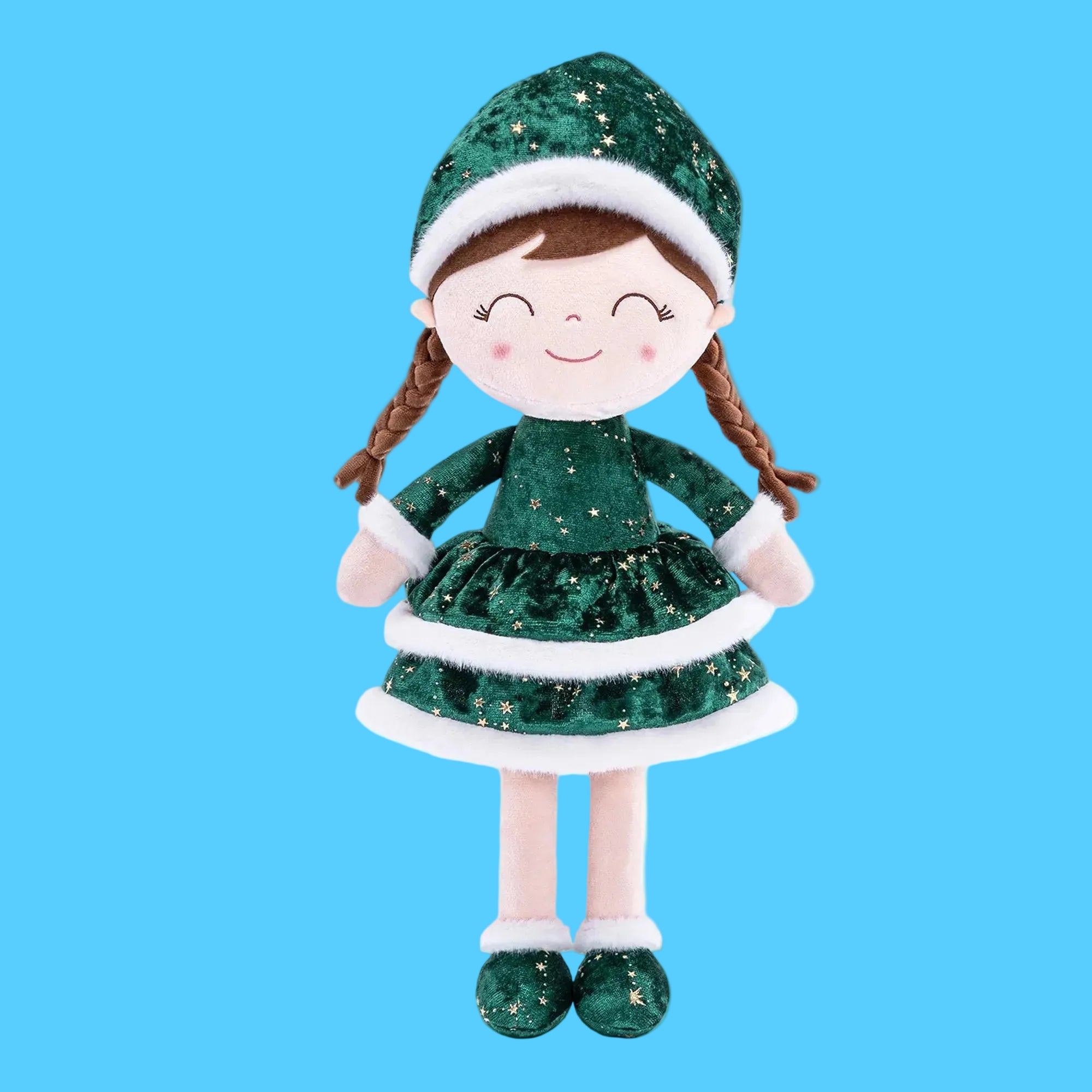Boneca de pano artesanal com tema de Natal usando roupa de elfa ou duende em tecido verde brilhante com glitter, vestido com bordas de pelúcia branca, gorro combinando e duas tranças castanhas, sobre fundo azul claro