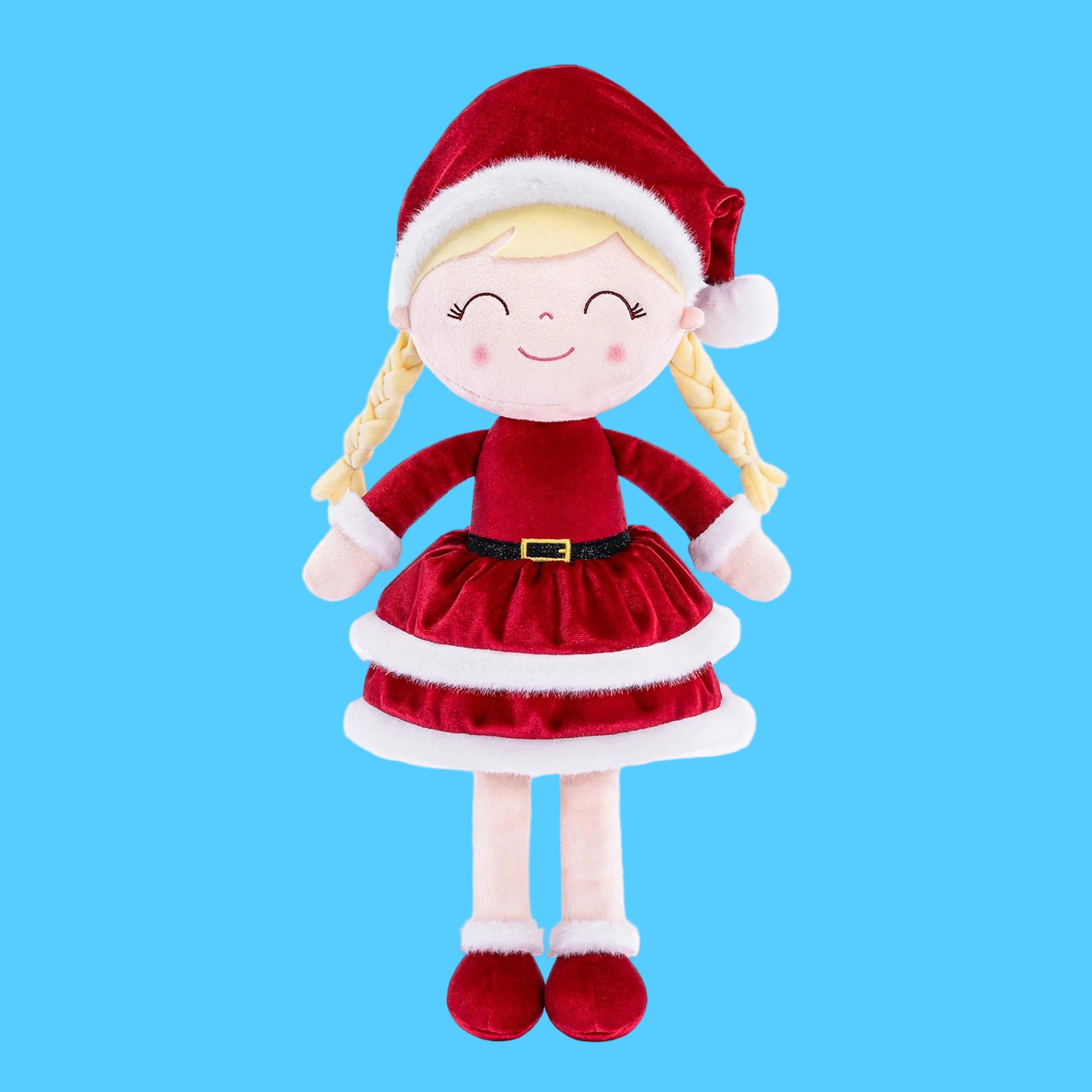 Boneca de pano artesanal com tema de Natal usando roupa de Mamãe Noel em veludo vermelho, saia rodada com bordas brancas de pelúcia, gorro natalino e duas tranças loiras, sobre fundo azul claro.