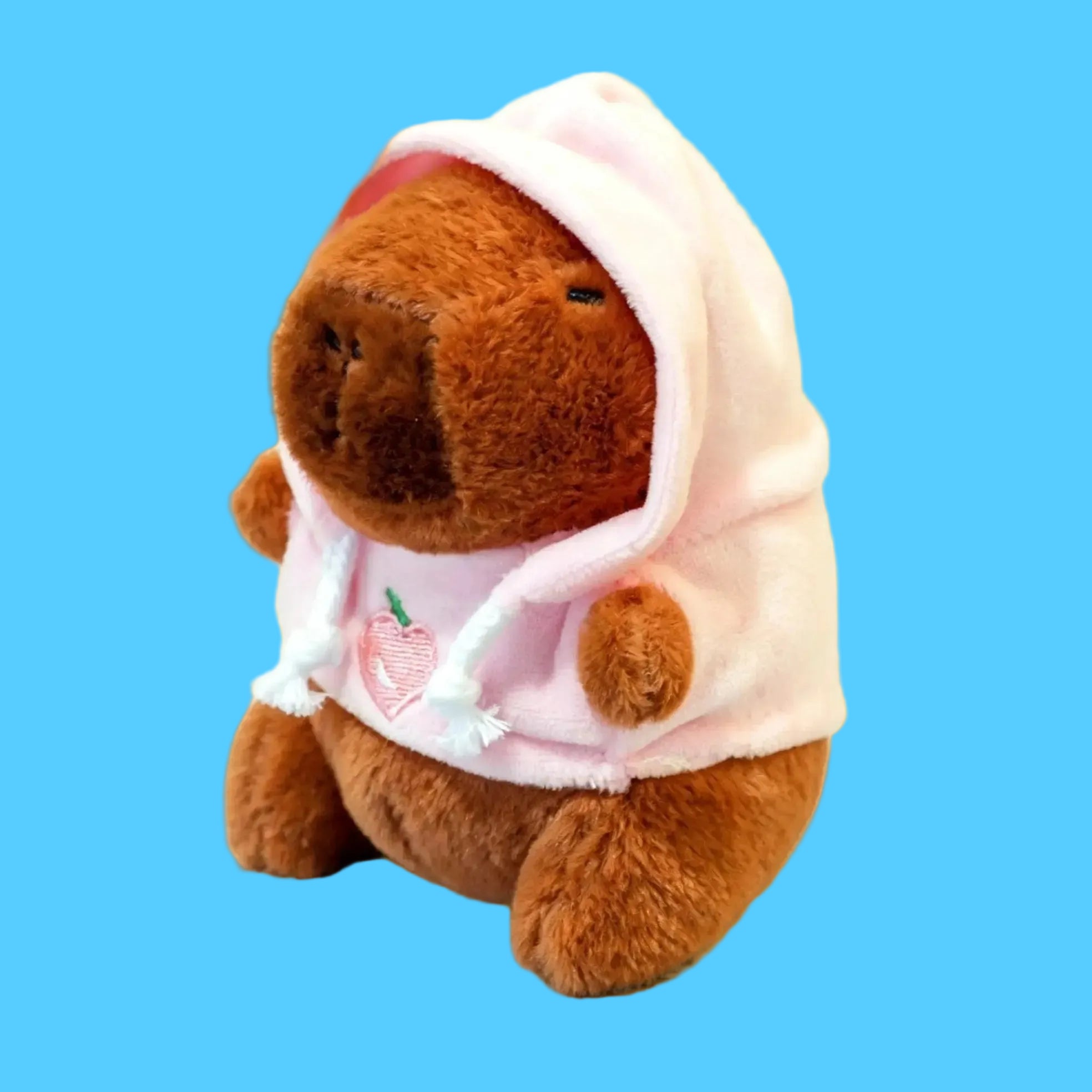 Brinquedo e Chaveiro de Pelúcia de Capivara Marrom Usando um Moletom Rosa com Capuz e Estampa de Pêssego